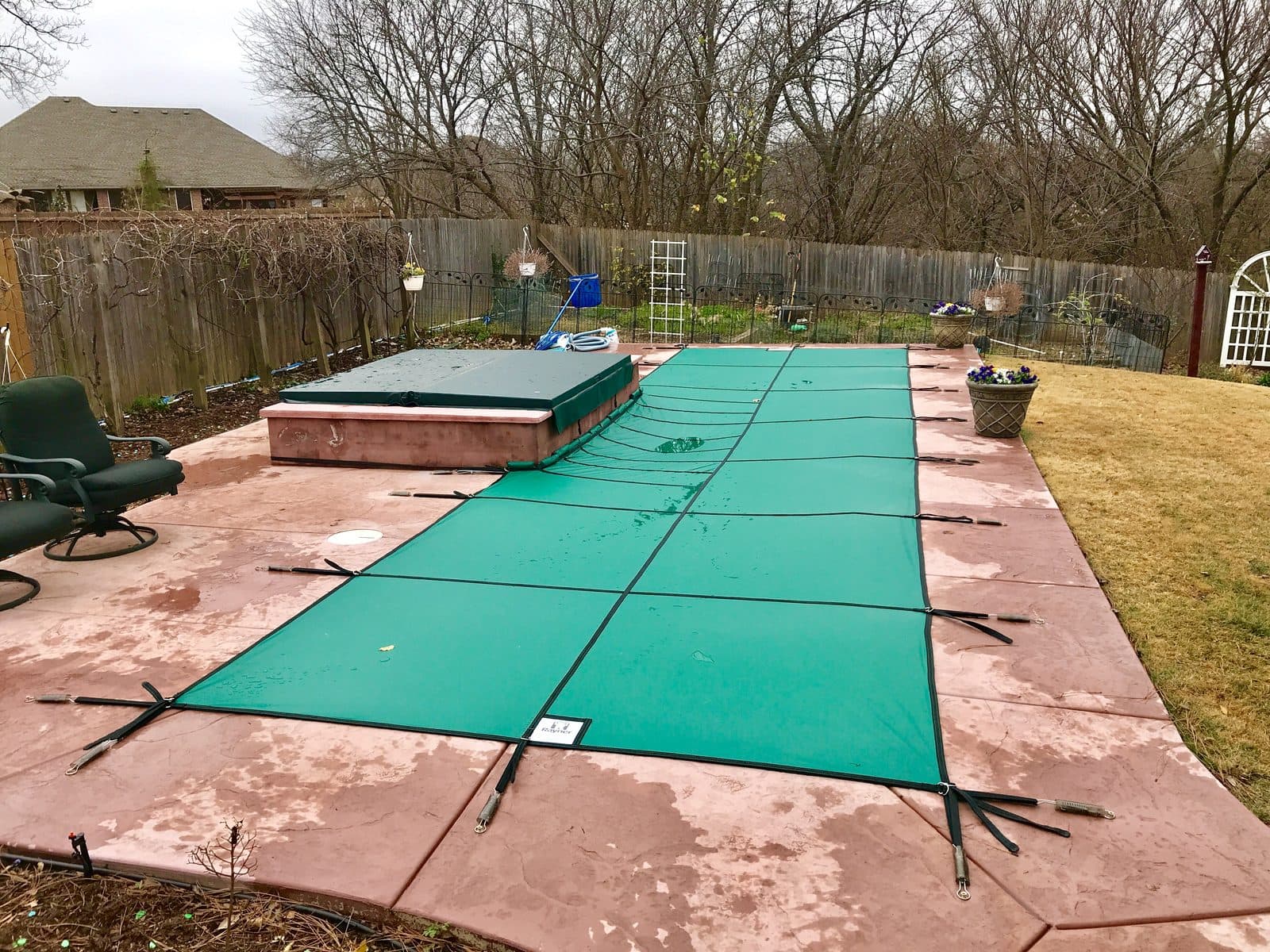 Safety cover and covered spa on an inground pool during an Oklahoma winter