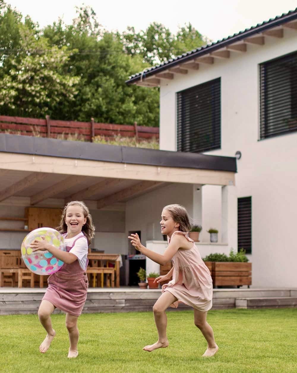 Children playing safely in a backyard with an inground pool