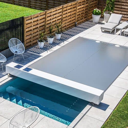 Grey cover closing over a courtyard pool